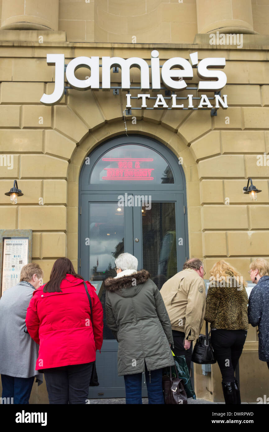 People reading menu outside Jamie Oliver`s Jamie`s Italian restaurant in Newcastle uopn Tyne, England,UK Stock Photo